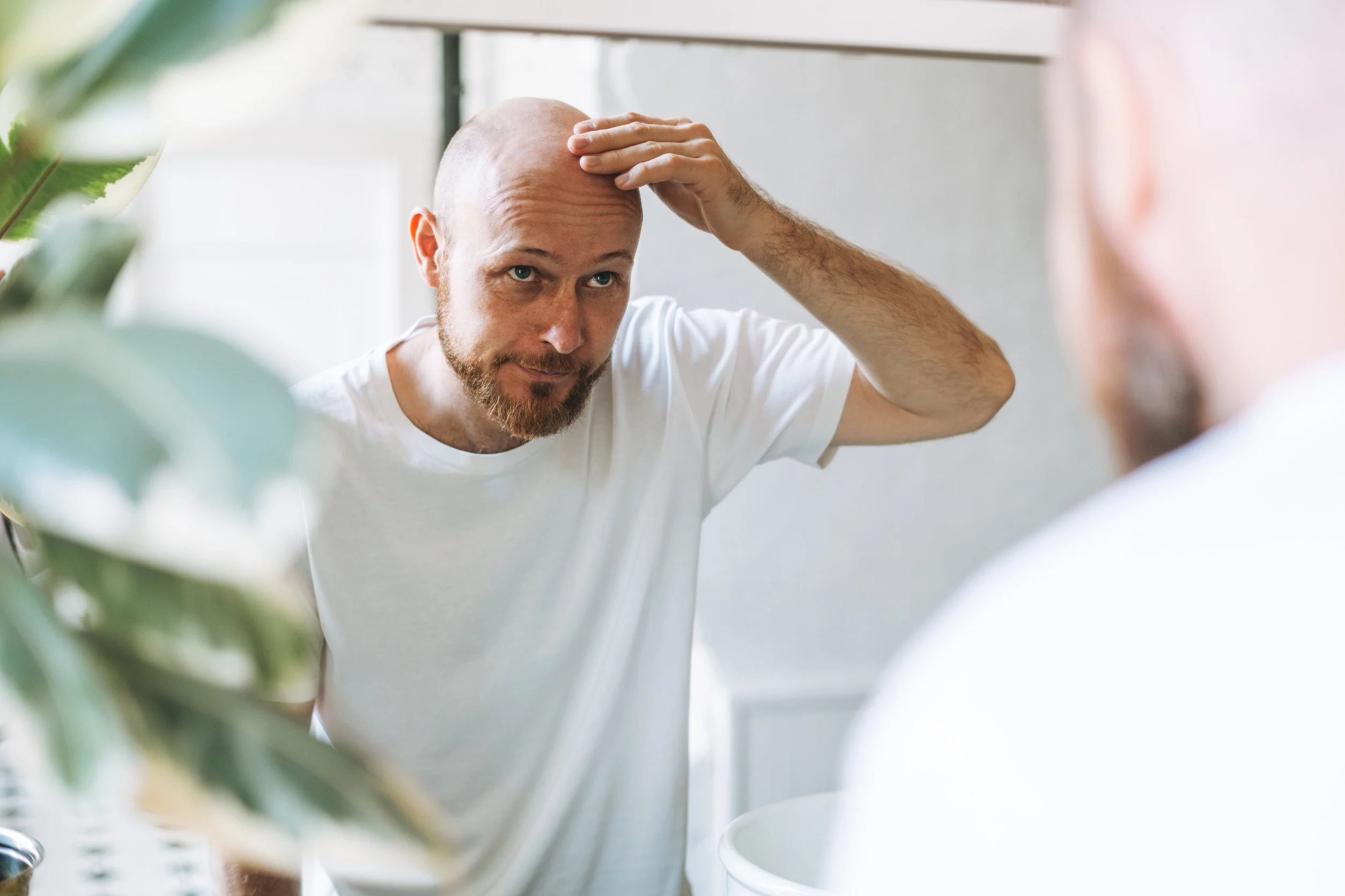 Un uomo che pensa alla cura per la calvizie.