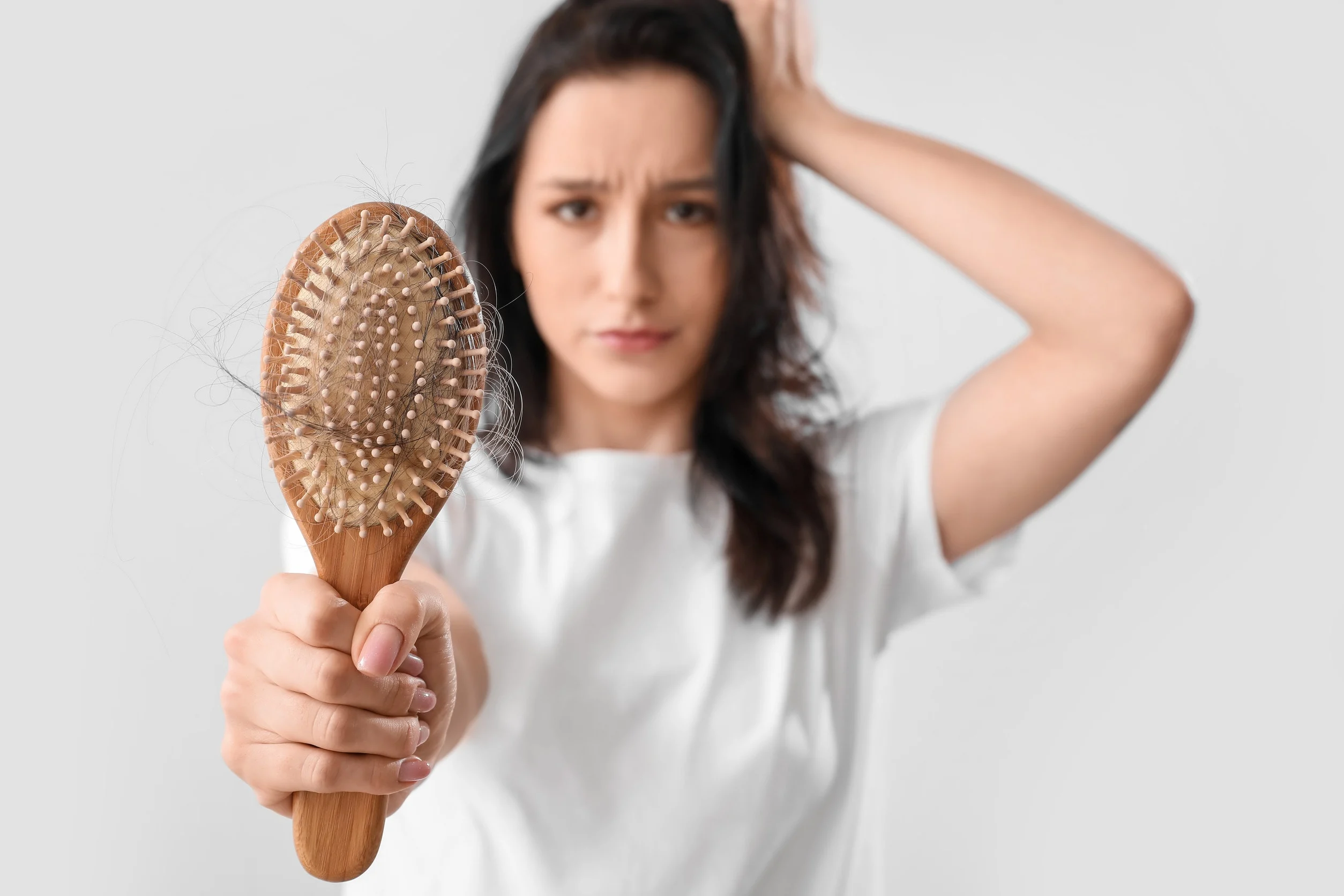 Una donna preoccupata per i capelli che restano nella spazzola.