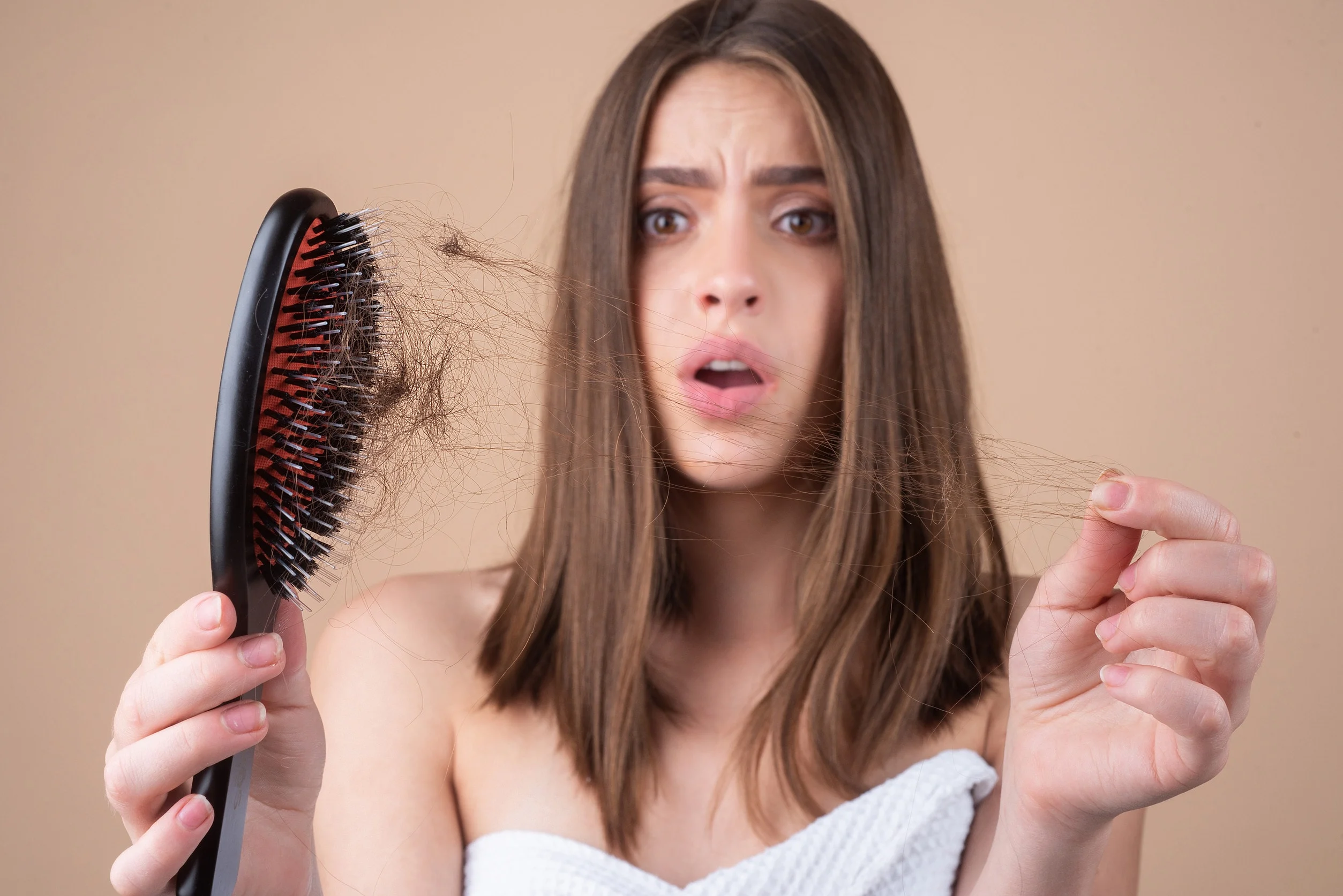 Una ragazza che ritrova ciocche di capelli sulla spazzola