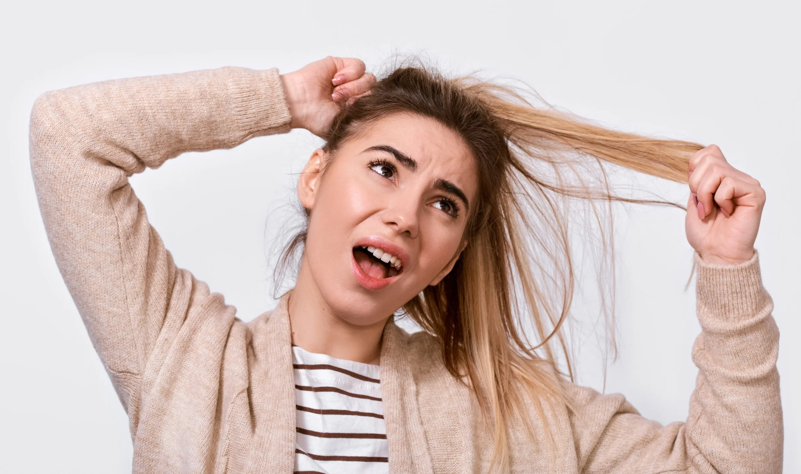 Una ragazza preoccupata dal fatto di avere capelli sottili e più deboli