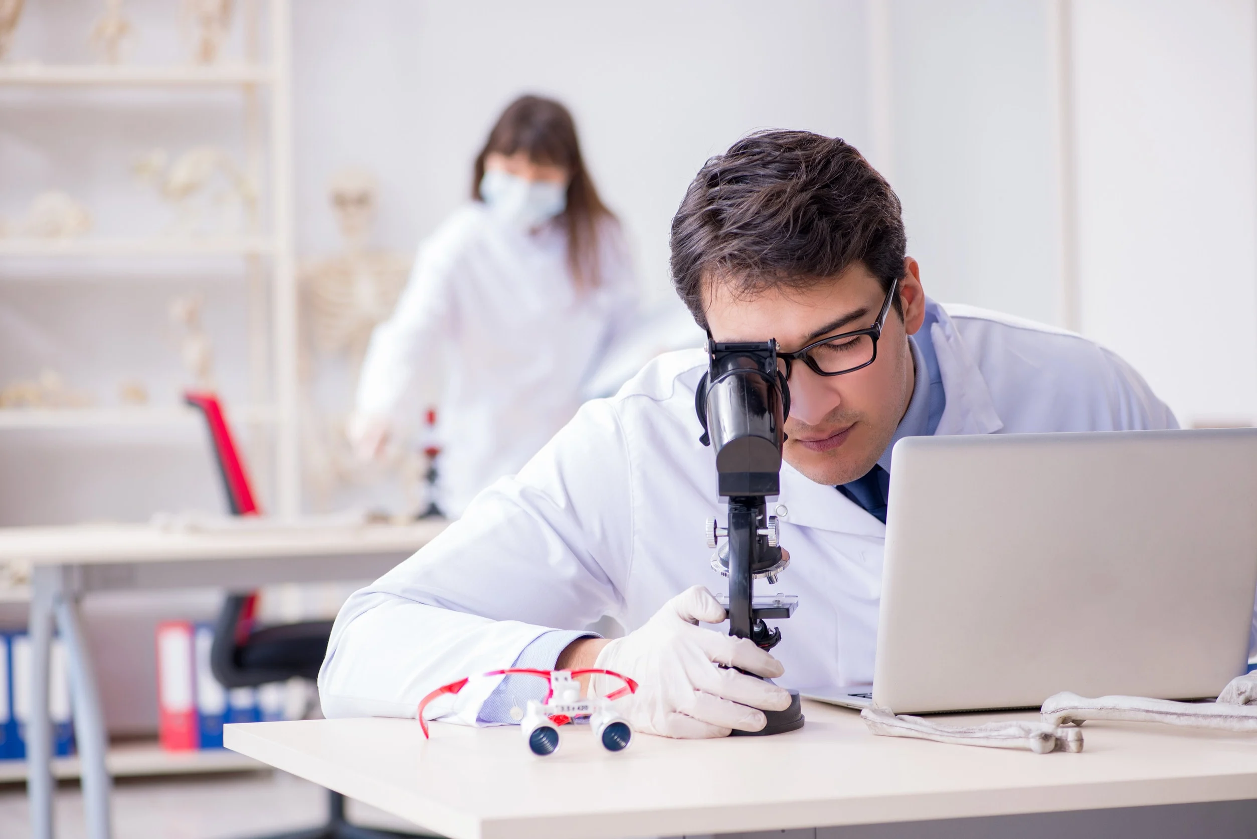 Un tricologo analizza un capello al microscopio.