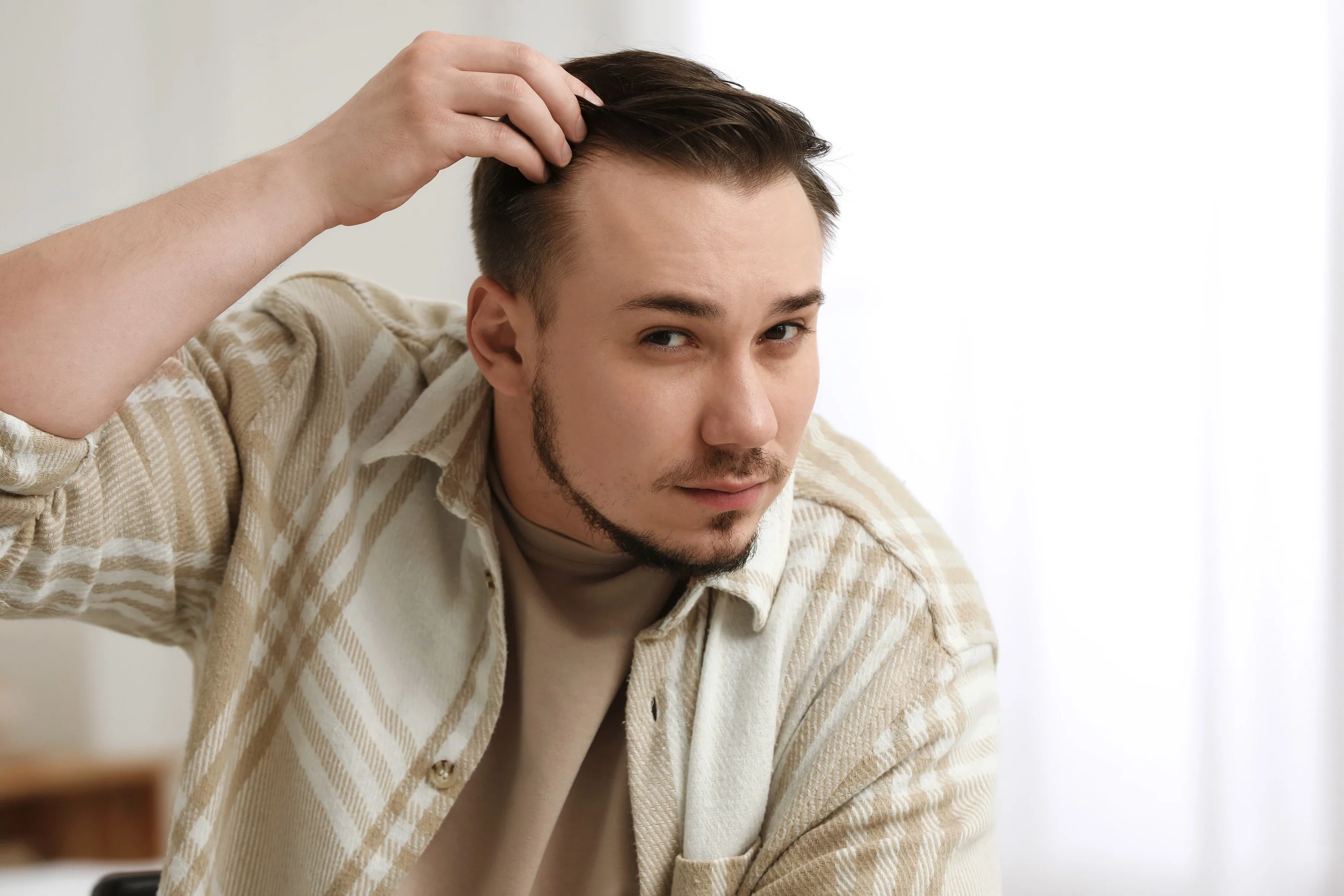 Un ragazzo che inizia a notare i primi segni di alopecia sulle tempie