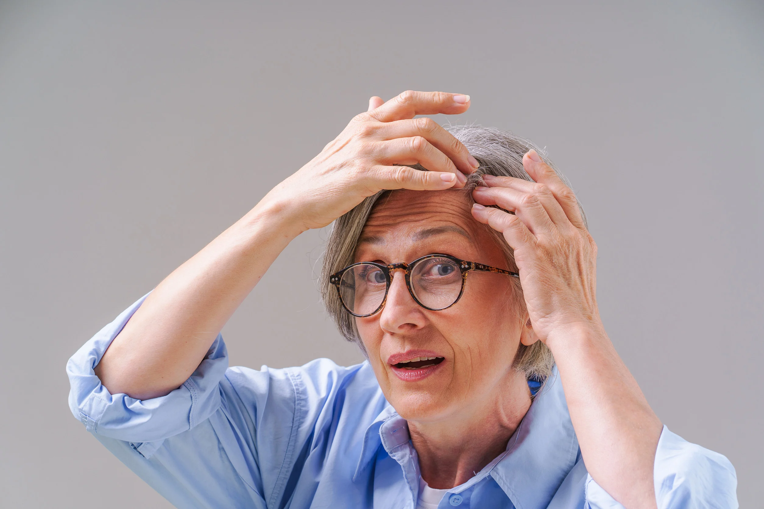 Una donna anziana che monitora la caduta dei capelli